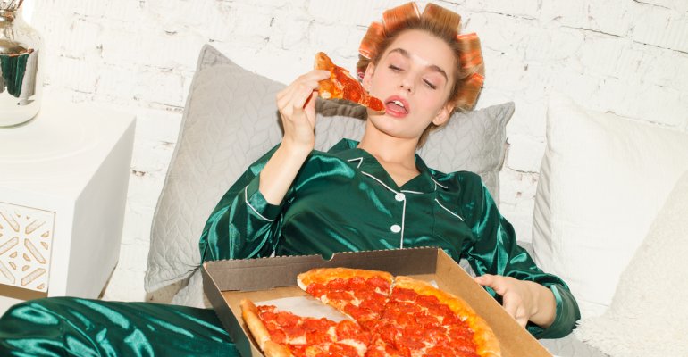 γυναίκα τρώει πίτσα λόγω διαταραχής υπερφαγίας